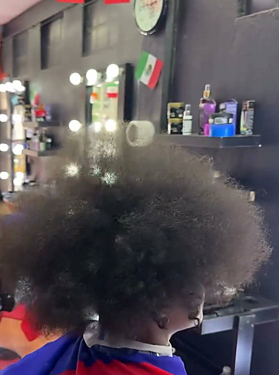 Antes: cabello afro largo y sin forma, visto desde atrás